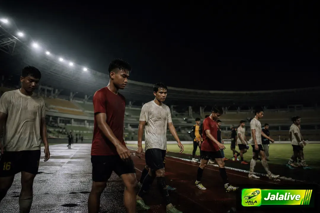Para pemain sepak bola berjalan di lapangan stadion Indonesia setelah pertandingan